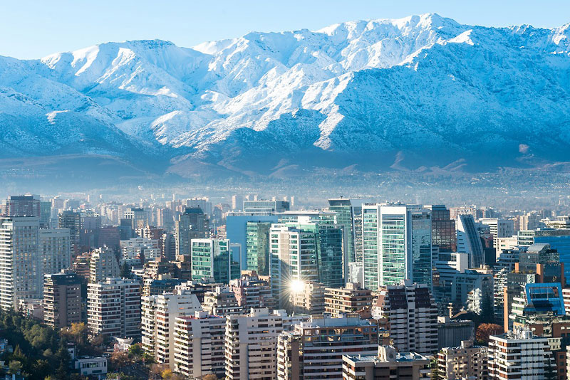 チリの首都・サンティアゴの街並みに迫るように連なるアンデス山脈